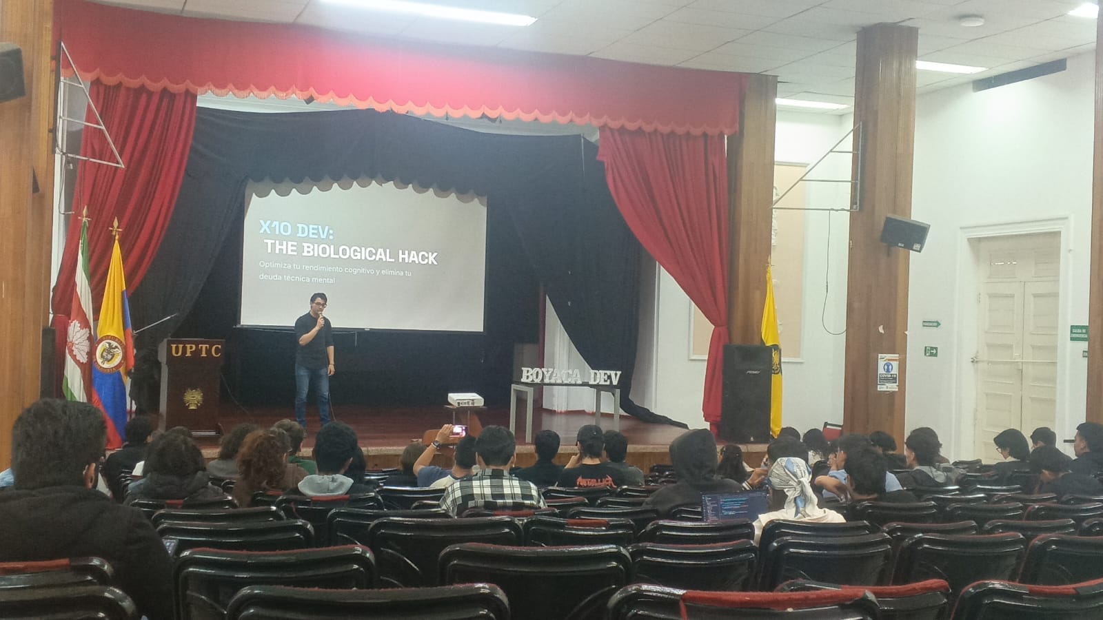 David dando una charla frente a estudiantes en el auditorio de la UPTC